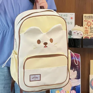 Detailed close-up view of a cute cream cat-themed backpack with embroidered facial features