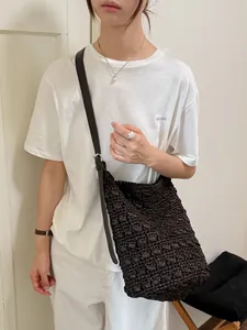 Modische minimalistische dunkelbraune gewebte Stroh-Eimertasche mit verstellbarem Lederriemen