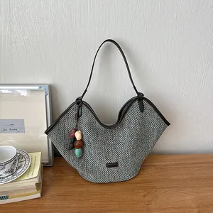 Handmade woven straw tote bag with colorful bead charm for casual beach holiday style