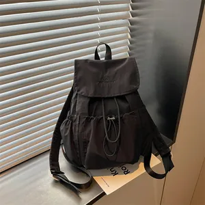Close-up of black drawstring backpack with embroidered logo and flap closure