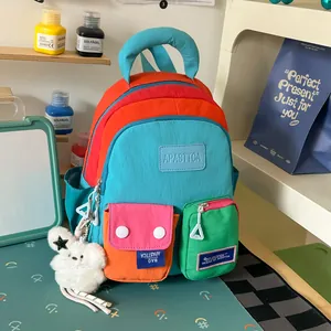 Close-up detail of a vibrant multi-colored fashion backpack featuring a plush bunny charm