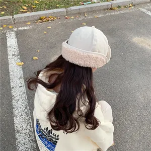 Detail back view of a cute beige plush earflap hat for women in warm winter style