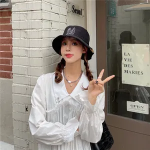 Stylish black cotton bucket hat featuring white rabbit ear embroidery on a female model