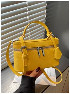 Close-up of yellow box handbag featuring textured leather and silver-tone hardware