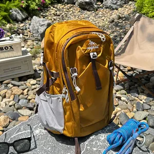 Durable mustard yellow hiking backpack displayed in a rugged outdoor camping setting