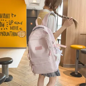 Leuke roze schoolrugzak met hartpatronen en sterhanger accessoire op een model