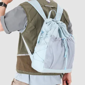 Back view of light blue drawstring backpack with mesh pockets on model