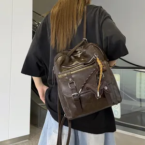 Back view of a large brown leather commuter backpack on a model.