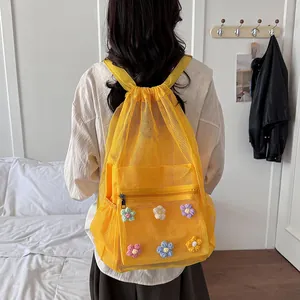 Back view detail of a trendy yellow mesh drawstring backpack featuring colorful knit flower accents