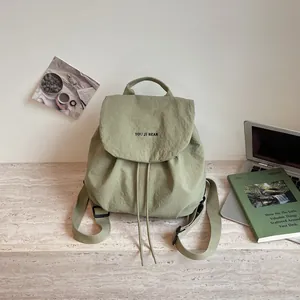 Sac à dos léger vert sauge pour fille dans un décor de bureau quotidien