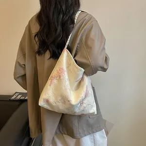 Elegant white floral embroidered shoulder bag featuring a unique twisted rope strap