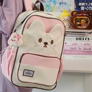 Detailed view of cute cat-themed backpack in pink and cream with a rabbit plush pendant
