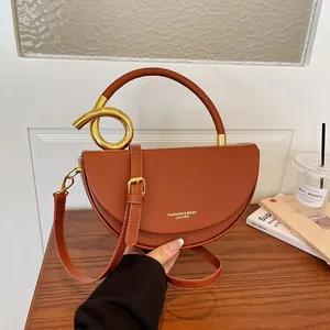 Detaillierte Nahaufnahme einer stilvollen braunen Satteltasche mit goldenem Griff