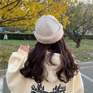 Back view of woman wearing a cozy beige Miki hat with plush fleece trim outdoors