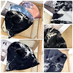 Close-up detail view of fashionable tie-dye slouchy beanies showing fabric texture and patterns
