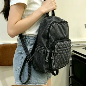 Detailansicht eines schwarzen Rucksacks mit gesteppter Vordertasche und Wascheffekt.