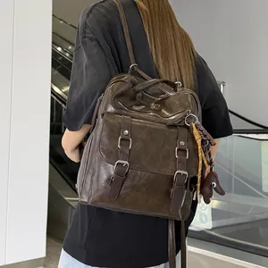 Detail of vintage dark brown faux leather commuter backpack with buckle pockets