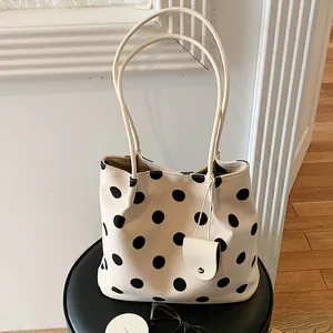 Chic French vintage cream tote bag featuring black polka dots and thin long shoulder straps