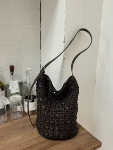 Handgewebte dunkelbraune Strohbeuteltasche mit verstellbarem Schulterriemen aus Leder