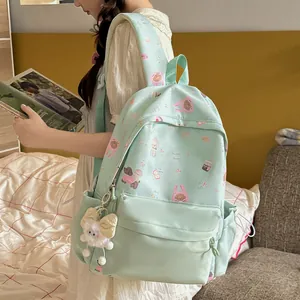 Detailed view of a sweet mint green backpack with cute animal patterns and a plush charm attached