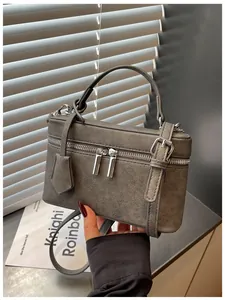 Elegant gray textured box style handbag featuring silver zipper details and a top handle