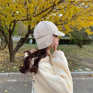 Stylish cream winter trapper hat with cozy ear flaps shown on a model in autumn park