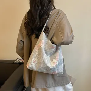 Detailed view showing the delicate floral embroidery and lace texture of this bucket bag.