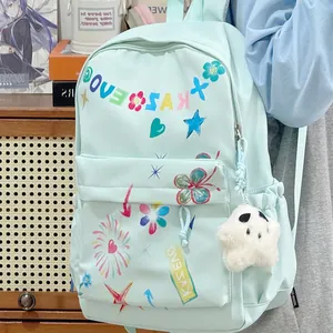 Close-up of a light blue fashion backpack with colorful graphic prints and a plush charm.