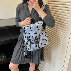Lifestyle view of a light grey polka dot backpack worn with a grey casual outfit