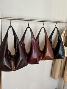 Bolsos hobo retro de gran capacidad en varios colores colgados en un perchero chic