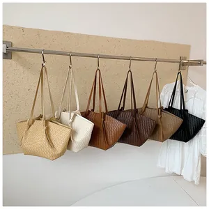 Collection of minimalist woven tote bags in various neutral colors hanging on a rod