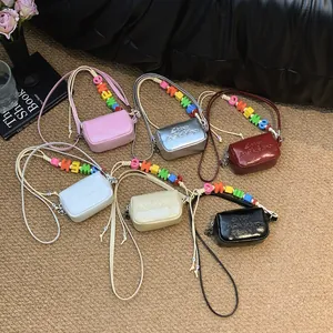 Detailed view of mini crossbody square bags in six colors with colorful letter bead straps