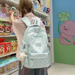 Pastelblauwe schoolrugzak met schattige strikpatronen gedragen in een winkelomgeving