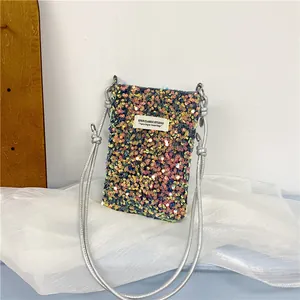 Dettaglio mini borsa per telefono in paillettes colorate con tracolla argento e etichetta.