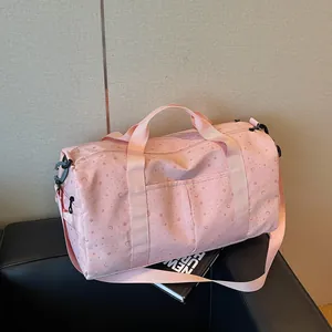 Bolso de viaje rosa de gran capacidad con motivos de estrellas y lunas sobre un sofá negro