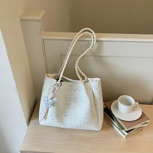 Sac fourre-tout blanc crème à motifs d'étoiles sur table en bois avec livres et café