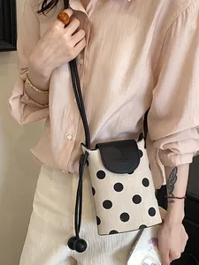 Stylish minimalist beige polka dot crossbody phone bag for women with black leather accents