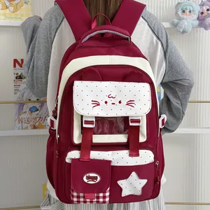 Vista detallada de la mochila escolar granate con diseño de cara de gato y estrellas