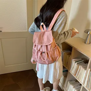 Back view of a stylish pink pleated drawstring backpack in a lifestyle setting