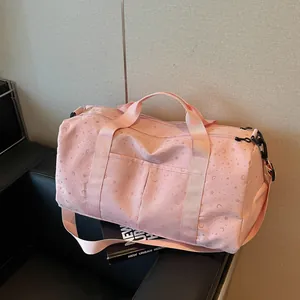 Vista detallada de bolsa de viaje rosa con textura de estrellas y lunas en asiento