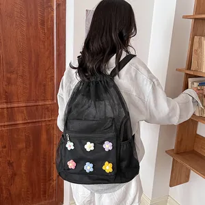 Detail view of black mesh backpack with colorful crochet flowers in a lifestyle setting