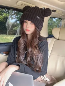 Bellissima modella asiatica che indossa un berretto nero con orecchie da orso in auto
