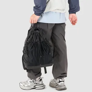 Versatile black drawstring backpack with grid pattern and mesh pockets for outdoor use