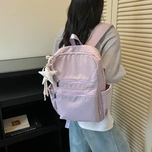 Vista trasera de una mochila ligera color lavanda en una modelo en un interior