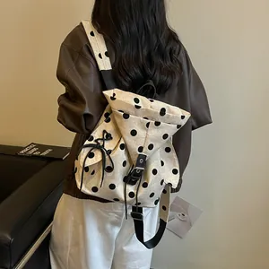 Detail view of large capacity beige canvas polka dot backpack with drawstring closure