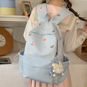 Sweet light blue student backpack featuring cute cartoon dog and cupcake patterns with plush charm