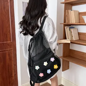 Stylish black mesh backpack featuring colorful crochet flowers on the model back view.