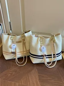 Fashionable striped woven tote bag for women with decorative plush charm accessory