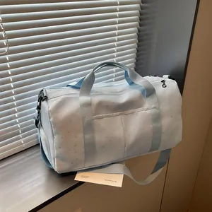 Detalle de una bolsa de viaje azul claro de gran capacidad con estrellas y lunas