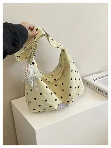 Detailweergave van de grote hobo-tas met zwarte stippen en een sterrenhanger